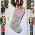 Dettaglio di una calza di Natale bianca con bordo rosa e motivo schiaccianoci appesa - Stile D