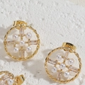 Macro detail of gold-plated hollow round earrings with pearl and zircon inlay on stone - Round Pearl Studs