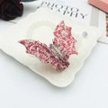 Dettaglio di un fermaglio per capelli a forma di ala di pipistrello con glitter rossi - Frammenti Rossi Fortunati