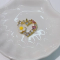Golden heart pendant with pink gems and daisy flower on white ceramic plate - Flower Heart