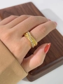 Dettaglio di un anello incrociato in oro 18K con strass indossato da una modella - US 8 / Oro
