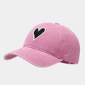 Close-up of vintage washed pink baseball cap featuring a black heart embroidery patch - Adjustable / Pink