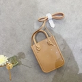 Mini beige PVC jelly handbag with dual handles and long shoulder strap on grey floor - Apricot