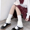 Close-up of white knitted Lolita leg warmers styled with black Mary Jane shoes - White