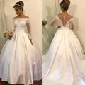 Elegantes Hochzeitskleid aus Satin mit Spitzenärmeln, Carmen-Ausschnitt und großer Schleife - US 2(S) / Elfenbein
