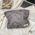 Detalle macro de la bolsa de cosméticos de pana gris con estampado de oso y tela suave - Gris