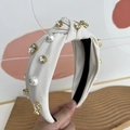 Detail of cream fabric knotted headband featuring white pearls and sparkling crystals - Beige