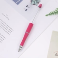 Adjustable pink beaded ballpoint pen with matte finish on a minimalist desk scene - Rose Red