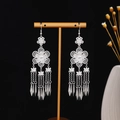 Dettaglio di orecchini etnici argentati con lunghe nappe e motivi floreali traforati - Nappa a Petalo (E3745-2) / Argento