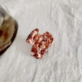 Amber tortoiseshell acetate hair claw clip with interlocking teeth on white fabric - Coffee Floral