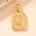 Macro shot of gold square pendant featuring an embossed letter J with sunburst border - Letter J
