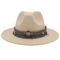 Detail of bohemian woven band with turquoise and tassels on a beige fedora hat - Beige