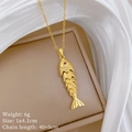 Macro-opname van gouden koi-visketting met rode steen op zijden juwelendoosje - Gouden Beweegbare Koi Hanger (E437)