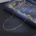 Collar de cadena dorada con colgantes de borlas de colores sobre un libro decorativo - Collar de Espina de Pescado Multicolor