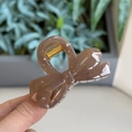 Detailed view of coffee brown bow-shaped hair claw clip with gold metal spring mechanism - Transparent Brown - Small Bowknot
