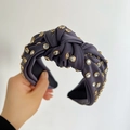 Close-up of knotted deep purple satin headband with crystals and golden metal claw settings - Navy Blue