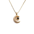 Gold-plated crescent moon necklace with cubic zirconia and a central black eye stone detail - Moon Evil Eye Projection Style / Gold