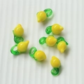 Macro shot of yellow glass lemon pendants with green stems for DIY jewelry making - 58# Lemon