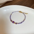Vista detallada de la pulsera de cuentas de amatista con detalles dorados en plato - Pulsera-Amatista