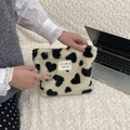 Close-up of soft plush heart pattern makeup bag held by hand for scale and texture - Black and White Heart