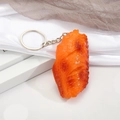 Realistic roasted chicken wing keychain with silver metal ring on white background - Orleans Chicken Wing