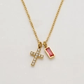 Close-up of gold cross necklace featuring clear zircon and red rectangular gemstone - July/Red