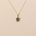 Collana a tartaruga placcata in oro con smalto nero e zirconi su sfondo beige - Nero
