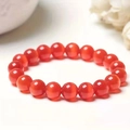 Polished red agate beaded bracelet featuring translucent round gemstones on elastic cord - 10mm Red