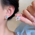 Elegant star-shaped stud earrings in bright silver with light blue center stone - Sky Blue Star Silver
