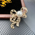 Broche nœud doré élégante avec une perle blanche centrale et des accents en strass - BZ063 Perle Nœud