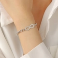 Minimalist infinity heart bracelet in silver metal worn on wrist for trendy women - Hollow Heart Infinity Symbol (White Gold Plated)