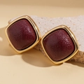 Macro shot of vintage square gold stud earrings with deep red pear-skin texture detail - Silver Earring Post - Red