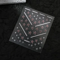 Detailopname van 3D-nagelstickers met sterpatronen op een zwarte gestructureerde achtergrond - CO-551 Zilveren Stempel