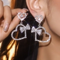Elegant silver heart bow drop earrings with sparkling rhinestones worn by a model - Silver Heart Bow Style (DTE1516027S-W)