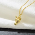 Macro shot of 18k gold plated wolf head pendant with pink zircon eyes on white fabric - Gold Fox Head-Pink Eyes