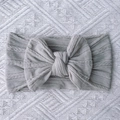 Detail of grey knitted baby headband featuring ribbed texture and large soft bow - Gray