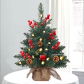 Close-up of a tabletop Christmas tree with warm LED lights, berries and pine cones - SYS124