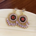Macro view of vintage gold earrings with red zircon, purple beads and fringe tassels - Gold Purple Flower (12#)