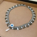 Close-up of woven beaded necklace featuring a blue gemstone and teardrop pearl pendant - Gray