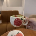 Nahaufnahme einer handbemalten Apfel-Keramiktasse mit Matcha und passender Untertasse - Handbemalter Apfel