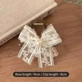 Elegant off-white lace bow hair clip with pearl detail and dark acrylic spring clamp - Lace Bow Claw Clip