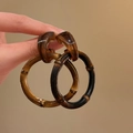 Close-up of bamboo-style leopard print resin hoop earrings held by hand - Bamboo Style Brown Hoop (61# Silver Earring Post - Coffee)