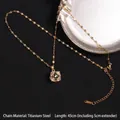 Gold rotating clover necklace with black petals and white crystals on a metallic tray - Rotatable Style 56 Black Enamel (A710)