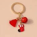 Detail of Christmas keychain with red tassel, bell, and festive stocking pendant - Red Christmas Sock