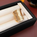 Dettaglio di un anello geometrico largo dorato in una lussuosa scatola di pelle nera - Oro