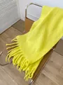 Bright yellow thick mohair scarf with tassels on a leather chair in a cozy room - Goose Yellow