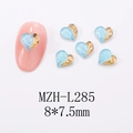 Detalle macro de adornos de uñas de corazón en azul brillante y dorado sobre blanco - L285-Corazón de Purpurina Azul Claro