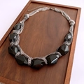 Détail de perles géométriques noires sur un collier argenté multi-rangs dans un plateau - Noir-Argent