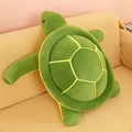 Soft green sea turtle plush pillow shell shown on a yellow fabric sofa - 25cm
