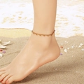 Goldene Fußkette aus Edelstahl mit kleinen Perlen vor Strandhintergrund für den Sommer - Gold (KJ4600-ZJZL)